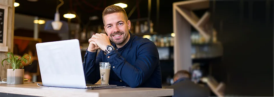 man sitting in a cafe and working on a laptop